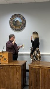 City Clerk Stuart Sylvester holds his right hand up as he swears in Nicole Kalloch in front of the Rockland seal